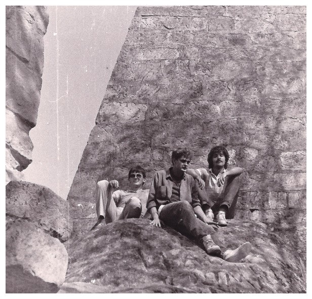 Trzech meżczyzn siedzących na murze