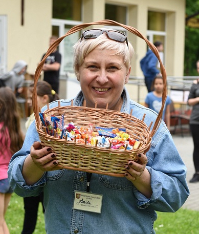 Nauczycielka trzyma w rękach koszyk ze słodyczami