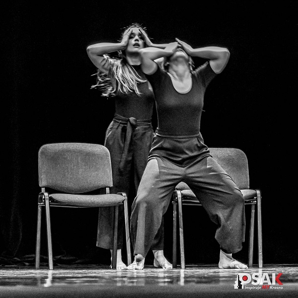 Dwie kobiety stojące przy krzesłach w tanecznej pozycji