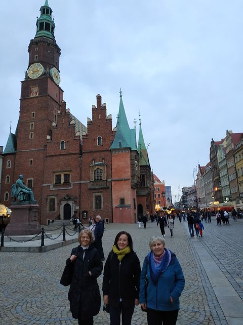 Trzy kobiety stojące na tle zabytkowej architektury