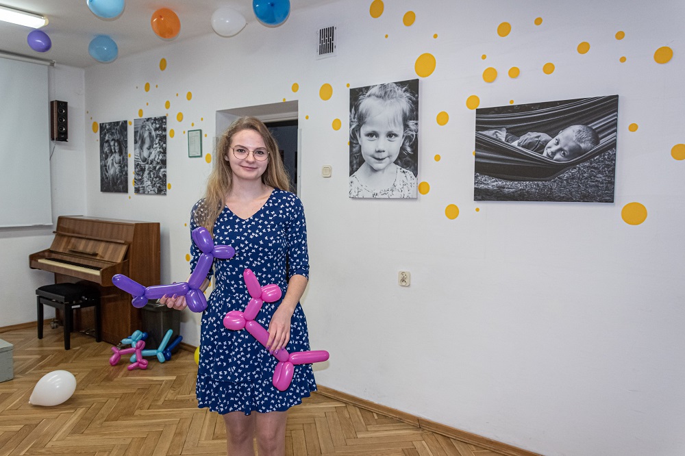 Słuchaczka Studium Magdalena Mielecka stojąca na tle swojej wystawy fotograficznej