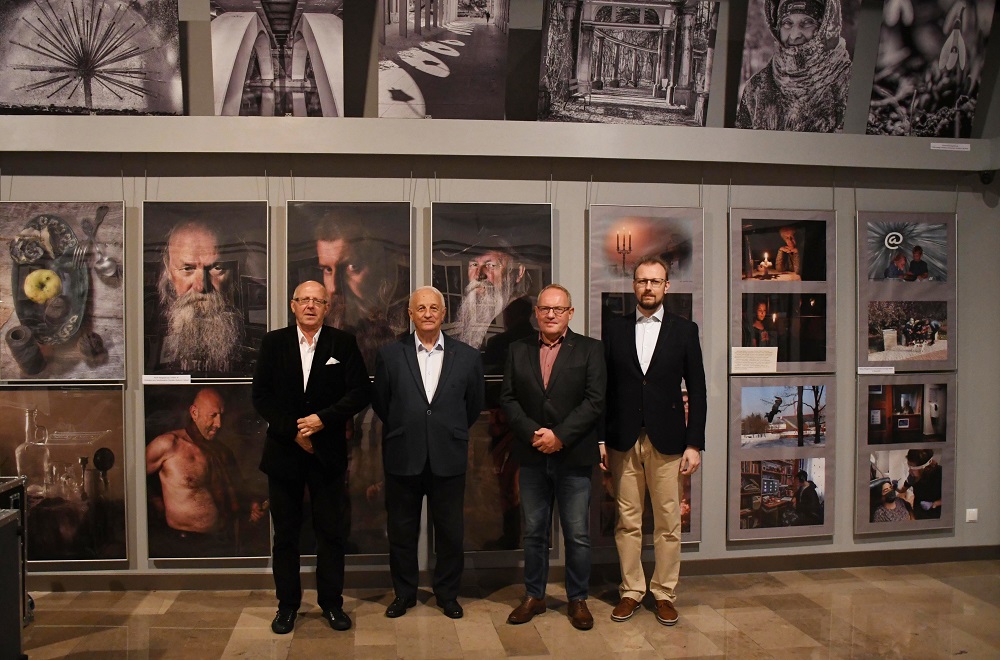 Mężczyźni stojący na tle zdjęć w galerii