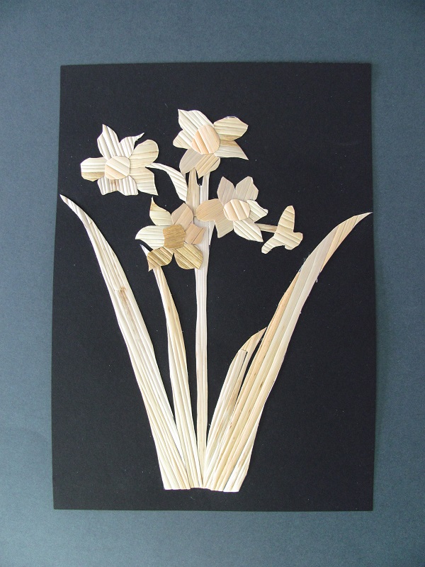 słomiane kwiaty przyklejone na czarnej kartce papieru