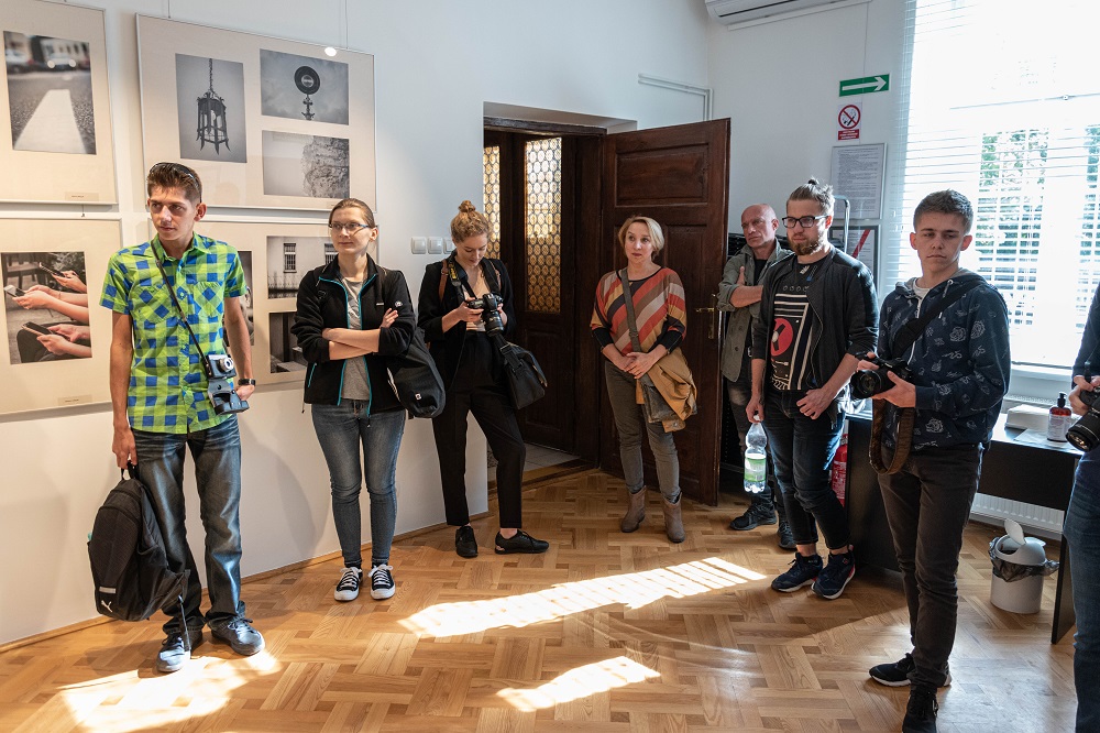 Grupa ludzi stojąca w galerii fotografii